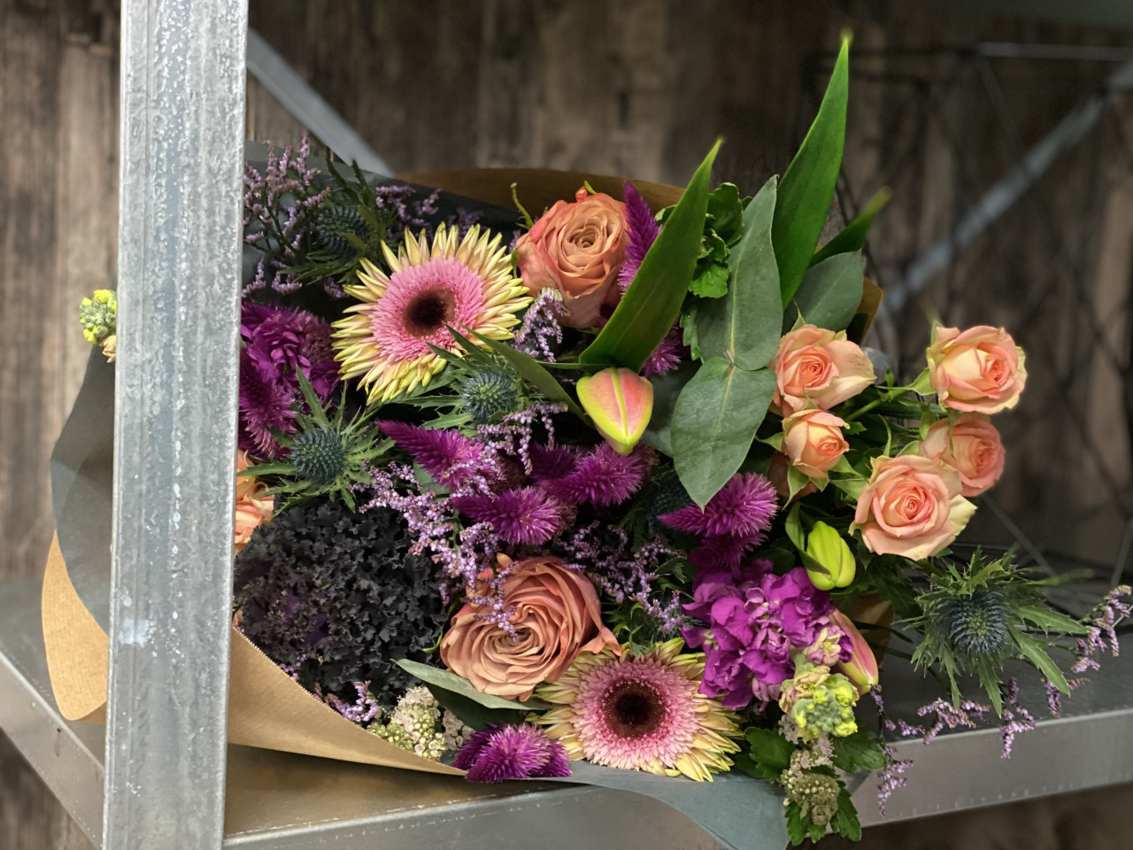 Hænder der holder mobiltelefon og tager billede af blomster