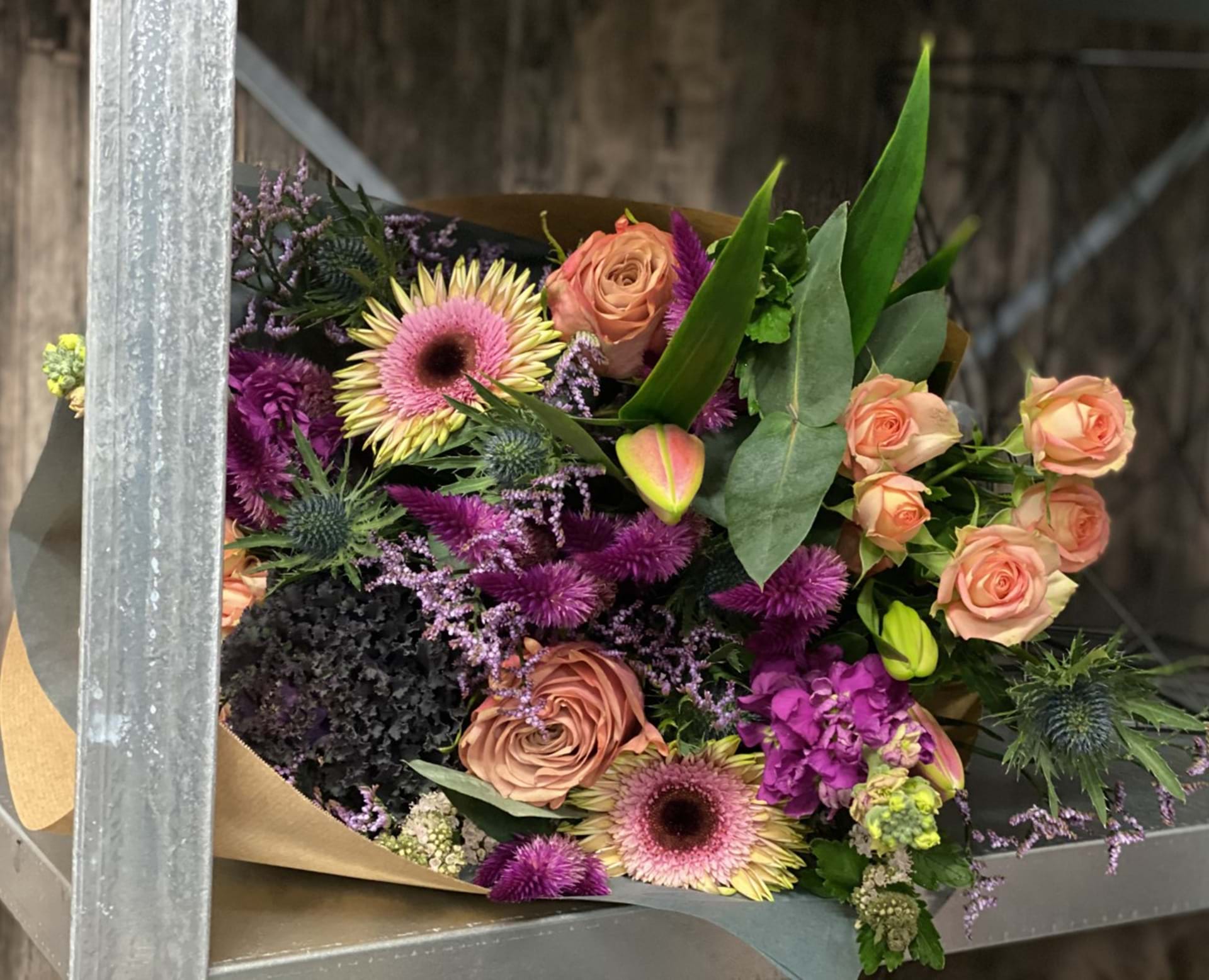 Hænder der holder mobiltelefon og tager billede af blomster
